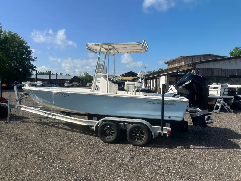 Slide: The Image of 2021 Cobia 21 Bay boat on trailer, parked outdoors under clear sky. - 3