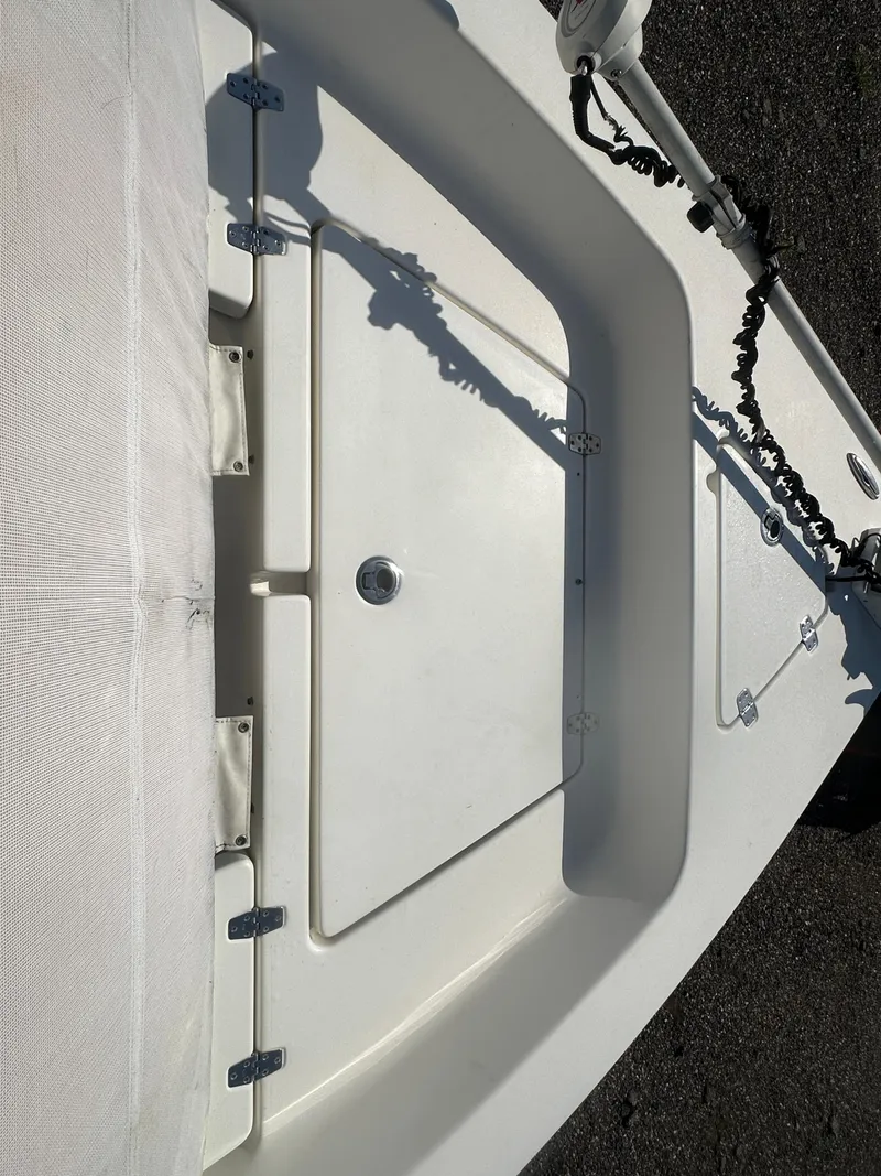 Slide: The Image of 2021 Cobia 21 Bay boat deck with storage compartment and mounted equipment. - 30