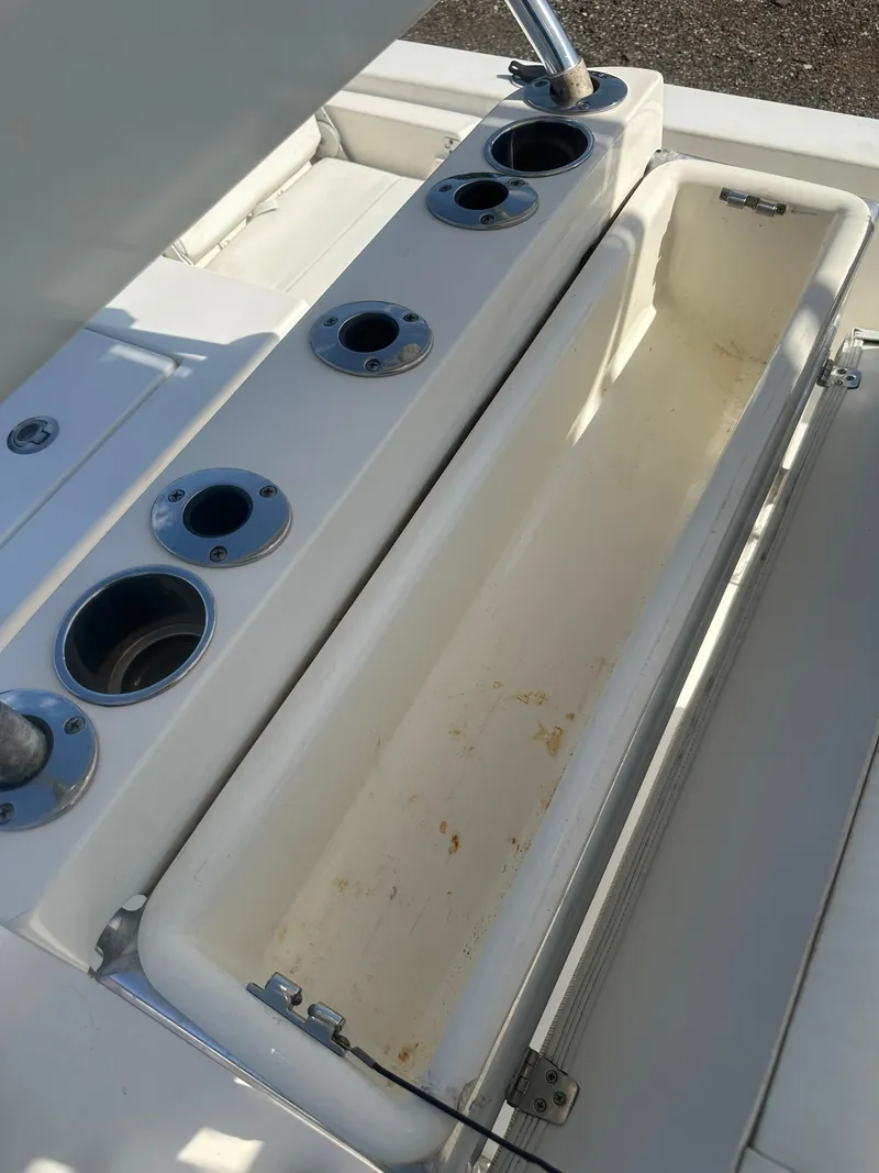 Slide: The Image of 2021 Cobia 21 Bay boat storage compartment with multiple cup holders. - 35
