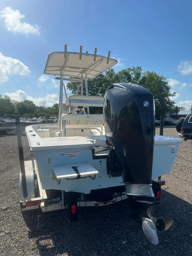 Slide: The Image of 2021 Cobia 21 Bay boat with outboard motor on trailer, sunny day. - 5