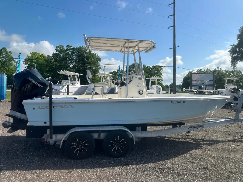 Slide: The Image of 2021 Cobia 21 Bay boat on trailer, parked outdoors under clear sky. - 7