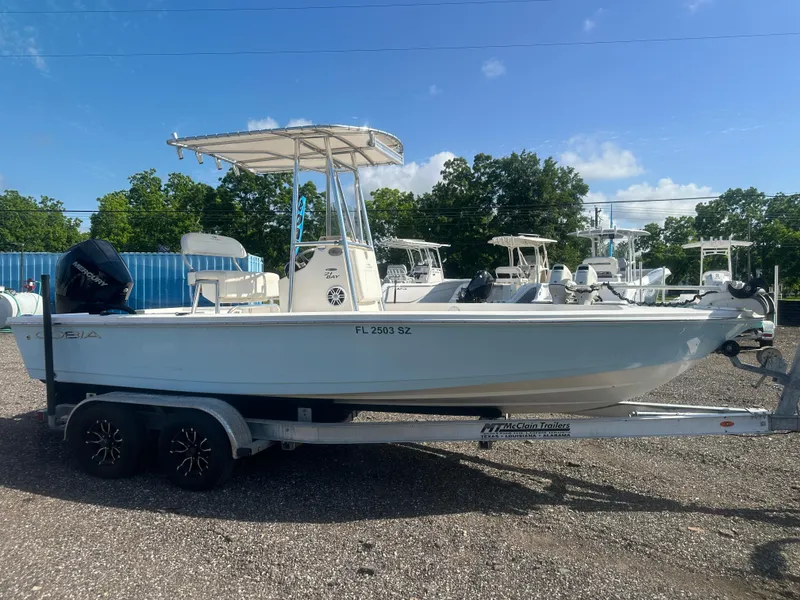Slide: The Image of 2021 Cobia 21 Bay boat on trailer, parked outdoors under clear sky. - 8