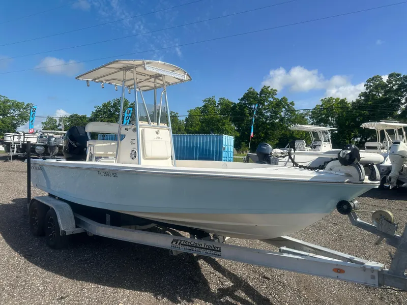 Slide: The Image of 2021 Cobia 21 Bay boat on trailer under clear blue sky. - 9