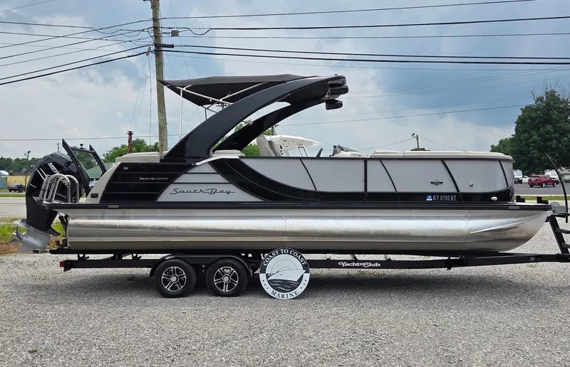 Slide: The Image of 2018 South Bay 725 RS ARCH DELUXE 3.0 pontoon boat on a trailer, parked outdoors. - 3