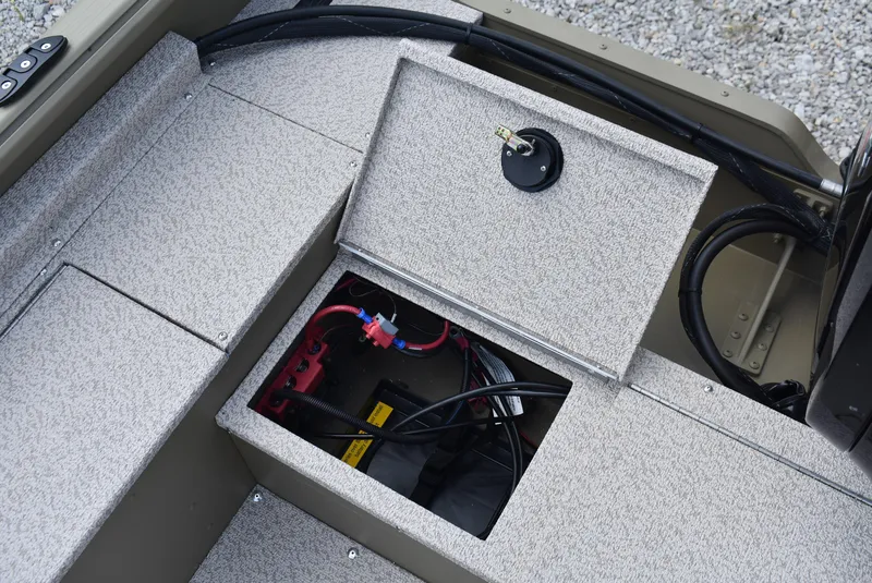 Slide: The Image of 2025 Lund 1875 Alaskan SS boat storage compartment with visible wiring and battery. - 14