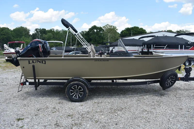 Slide: The Image of 2025 Lund 1875 Alaskan SS boat on trailer, parked outdoors under blue sky. - 4