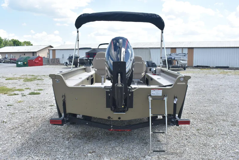 Slide: The Image of 2025 Lund 1875 Alaskan SS boat, rear view with motor and ladder, parked outdoors. - 5