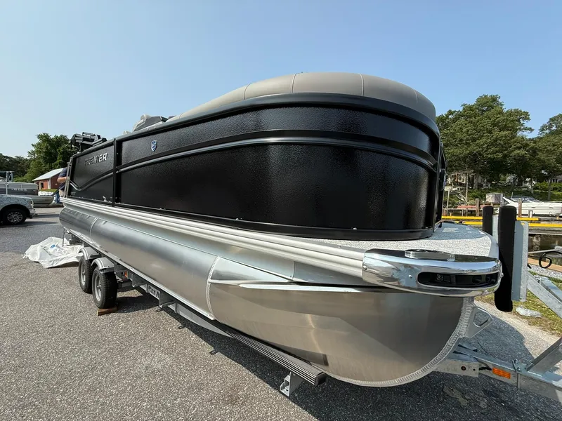 Slide: The Image of 2025 Premier 210 Sunsation RL pontoon boat on trailer, sleek black and silver design. - 12