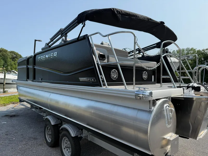 Slide: The Image of 2025 Premier 210 Sunsation RL pontoon boat on trailer, featuring sleek black design. - 16