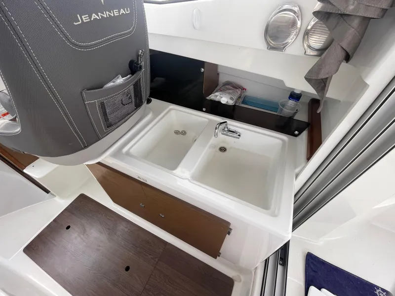 Slide: The Image of 2019 Jeanneau NC 695 boat interior with dual sinks and storage. - 13