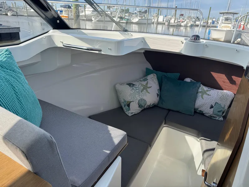Slide: The Image of Interior of 2019 Jeanneau NC 695 boat with cozy seating and decorative cushions. - 14