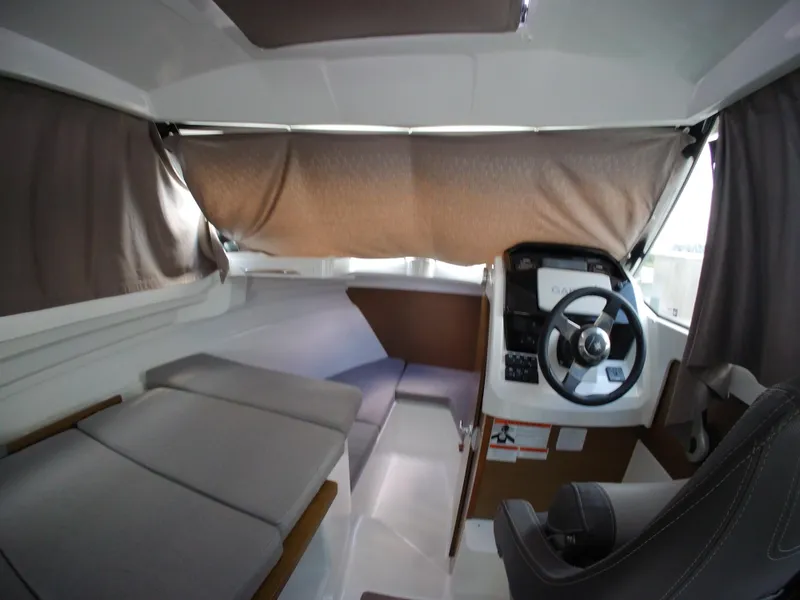 Slide: The Image of Interior of 2019 Jeanneau NC 695 boat with steering wheel and seating area. - 20
