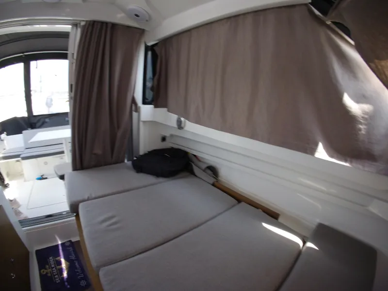 Slide: The Image of Interior of 2019 Jeanneau NC 695 boat with cushioned seating and curtains. - 25