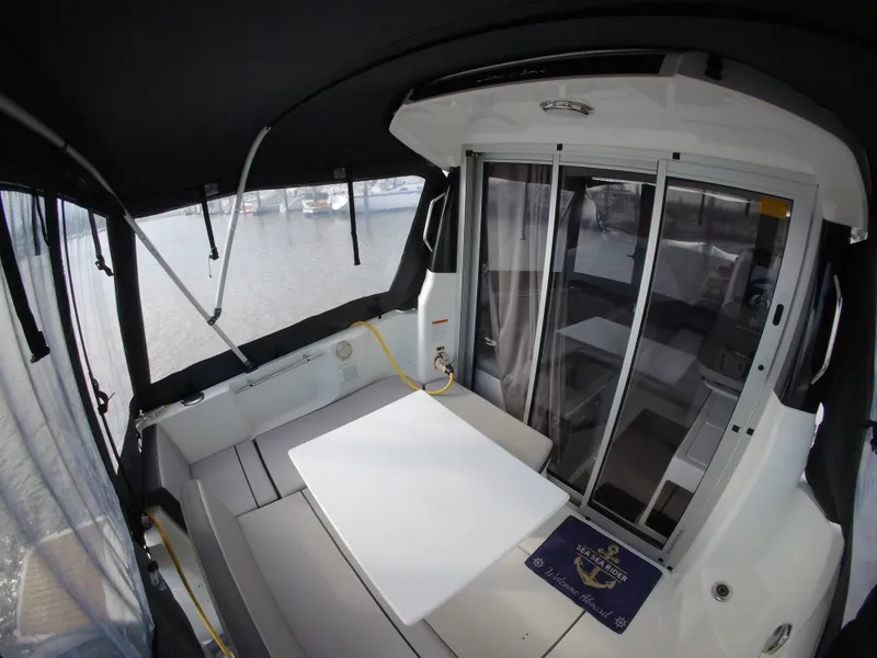 Slide: The Image of 2019 Jeanneau NC 695 boat interior with seating and sliding glass doors. - 28