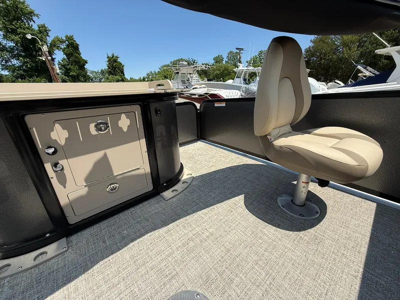 Slide: The Image of 2025 Premier 230 Sunsation Angler 2pt interior with seating and storage, under clear blue sky. - 12