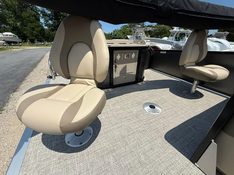 Slide: The Image of 2025 Premier 230 Sunsation Angler 2pt boat interior with beige swivel seats and carpeted floor. - 13