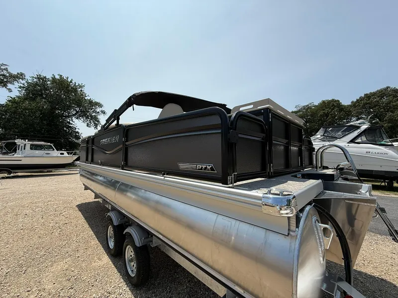 Slide: The Image of 2025 Premier 230 Sunsation Angler 2pt pontoon boat on trailer, parked outdoors. - 21