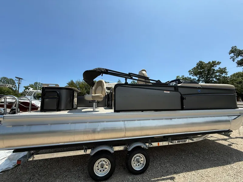 Slide: The Image of 2025 Premier 230 Sunsation Angler 2pt pontoon boat on trailer under clear blue sky. - 4
