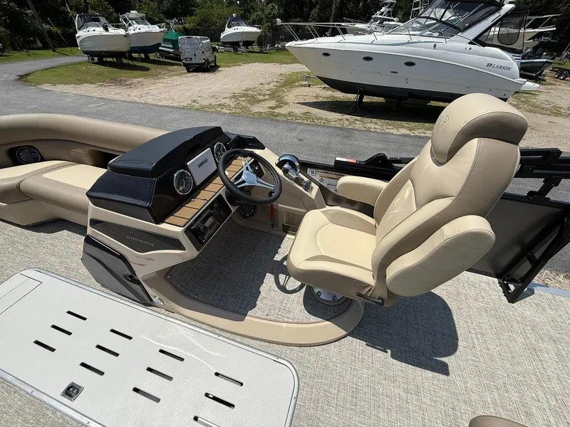 Slide: The Image of 2025 Premier 230 Sunsation Angler 2pt boat interior with beige seating and modern dashboard. - 7