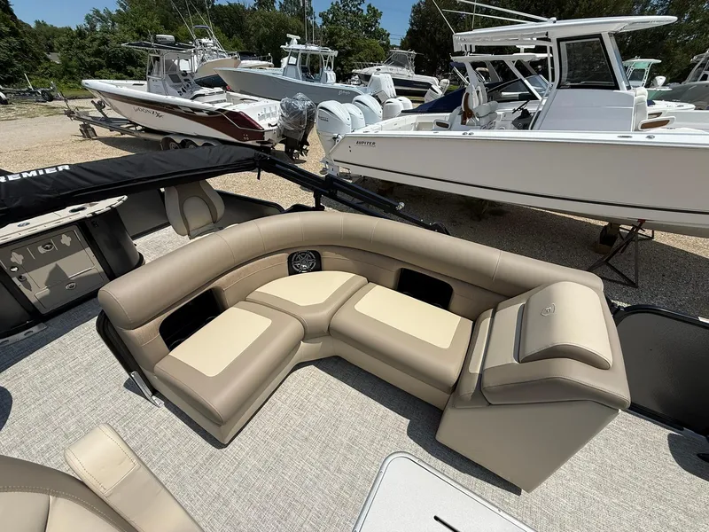 Slide: The Image of 2025 Premier 230 Sunsation Angler 2pt boat with beige seating, docked among other boats. - 8