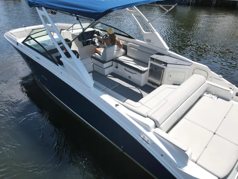 Slide: The Image of 2021 Sea Ray SDX 290 Outboard boat with blue canopy on calm water. - 12