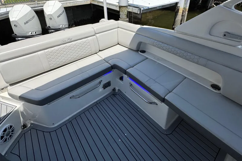 Slide: The Image of 2021 Sea Ray SDX 290 Outboard interior with gray seating and deck, docked by water. - 23
