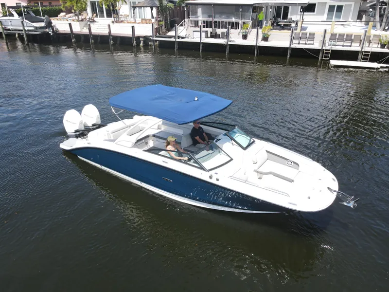 Slide: The Image of 2021 Sea Ray SDX 290 Outboard boat cruising on a calm waterway with blue canopy. - 3