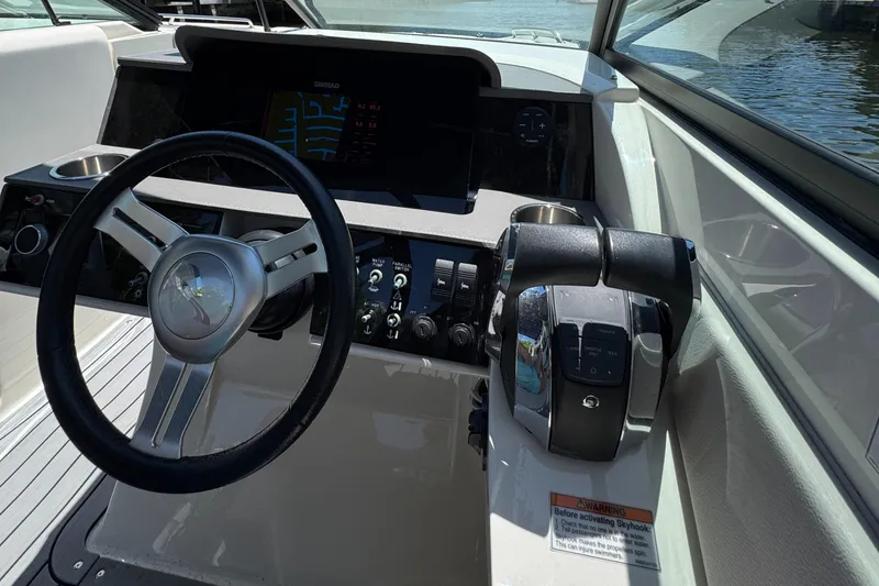 Slide: The Image of 2021 Sea Ray SDX 290 Outboard helm with steering wheel and control panel. - 31