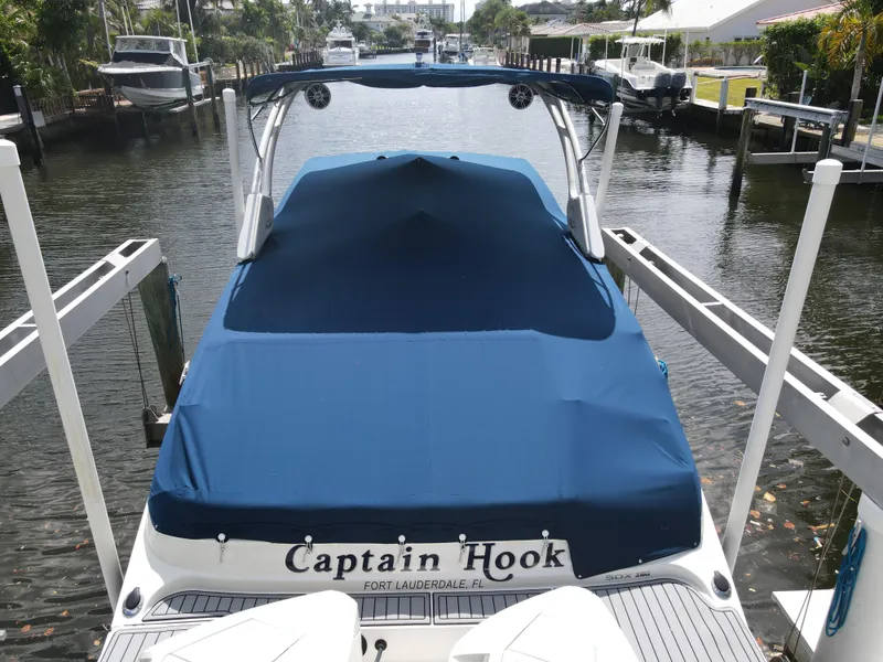 Slide: The Image of 2021 Sea Ray SDX 290 Outboard boat docked, covered with blue tarp, named "Captain Hook". - 38