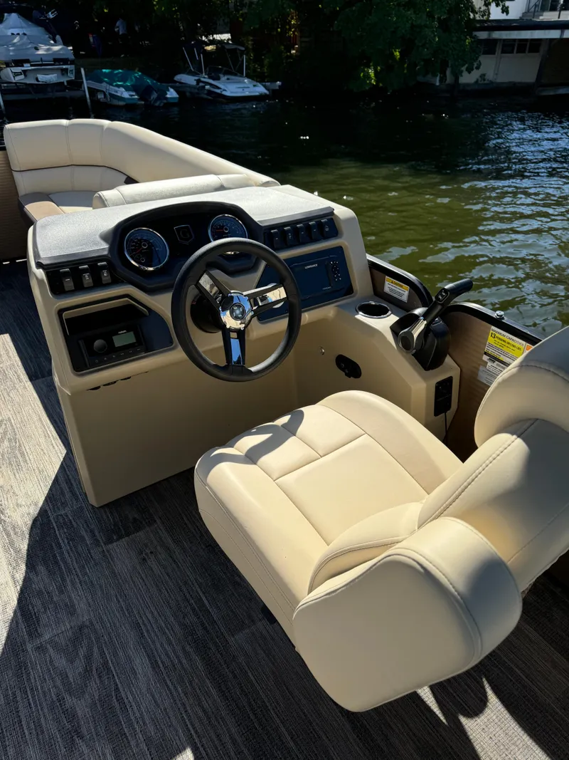 Slide: The Image of 2023 Godfrey SWEETWATER 2186 SB boat interior with steering wheel and beige seating. - 9