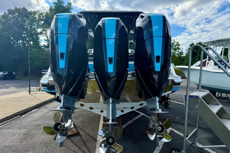 Slide: The Image of 2026 Nor-Tech 340 Sport boat with triple outboard engines, parked outdoors. - 10