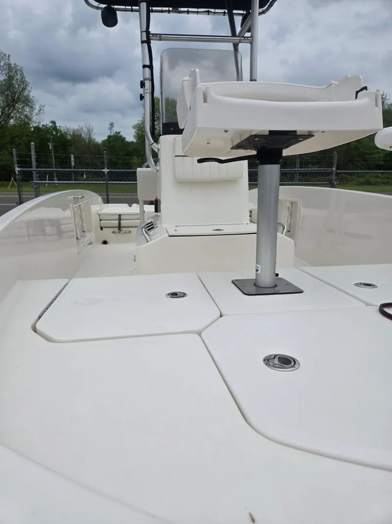 Slide: The Image of 2022 Bayliner Trophy T18Bay boat deck with seating and storage, under cloudy skies. - 12
