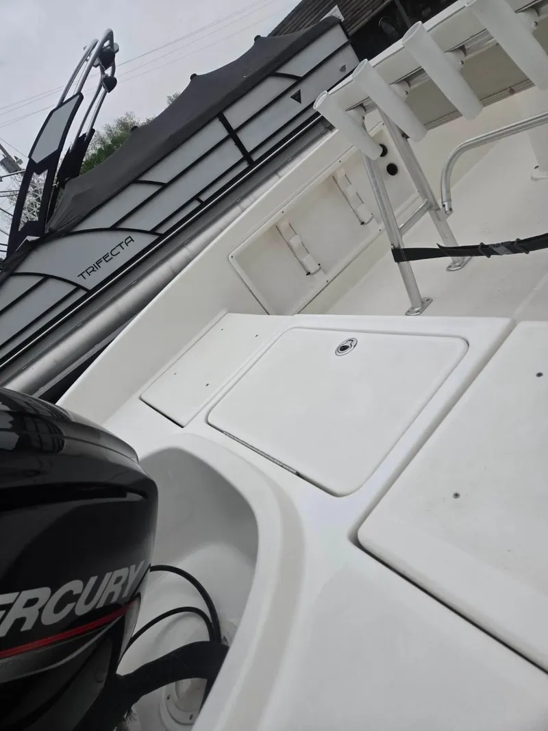 Slide: The Image of 2022 Bayliner Trophy T18Bay boat interior with Mercury engine, showcasing seating and storage. - 5