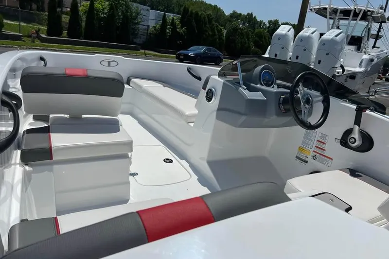 Slide: The Image of 2021 Tahoe T16 boat with white and gray seating, red accents, and steering console. - 5