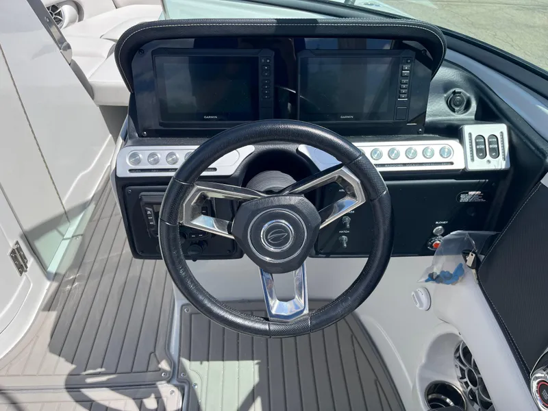 Slide: The Image of 2024 Crownline 270 SS boat dashboard with dual displays and modern steering wheel. - 10