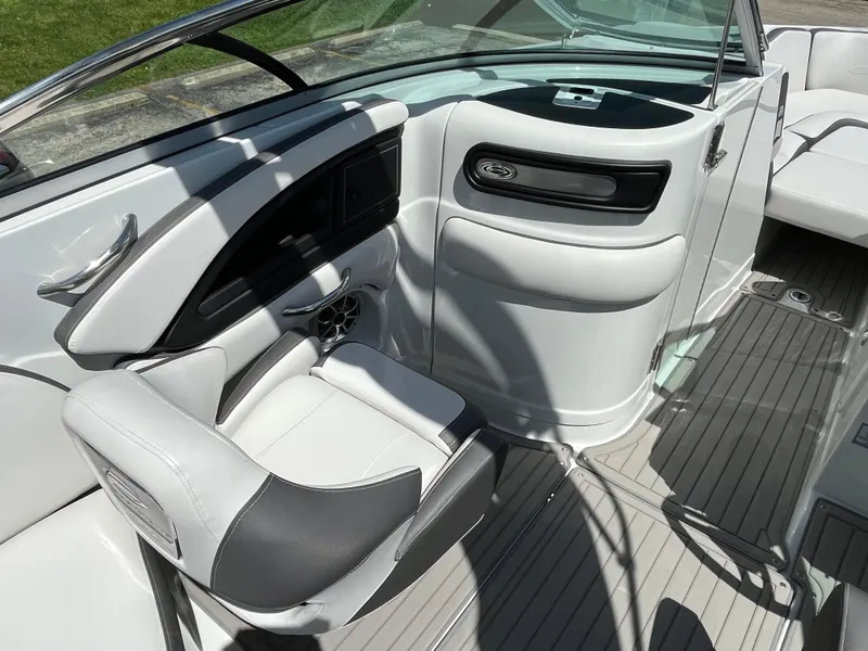 Slide: The Image of 2024 Crownline 270 SS boat interior with sleek white seating and modern dashboard design. - 12