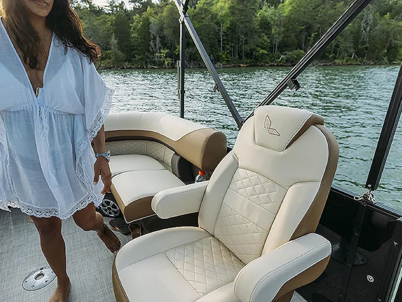 Slide: The Image of 2024 Lowe L-Shaped SS 210 boat interior with luxurious seating on a serene lake. - 10