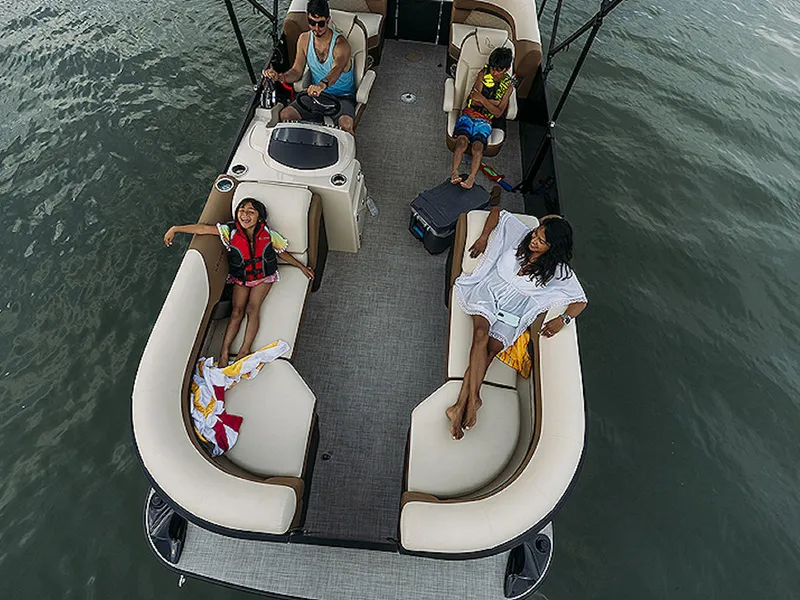 Slide: The Image of 2024 Lowe L-Shaped SS 210 pontoon boat with passengers enjoying a relaxing ride on the water. - 4
