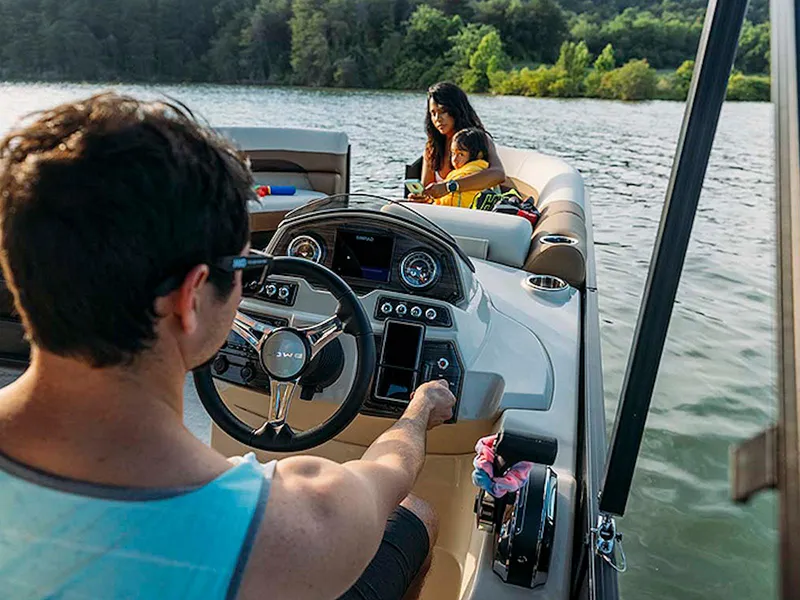 Slide: The Image of 2024 Lowe L-Shaped SS 210 boat on a lake with people enjoying a sunny day. - 7