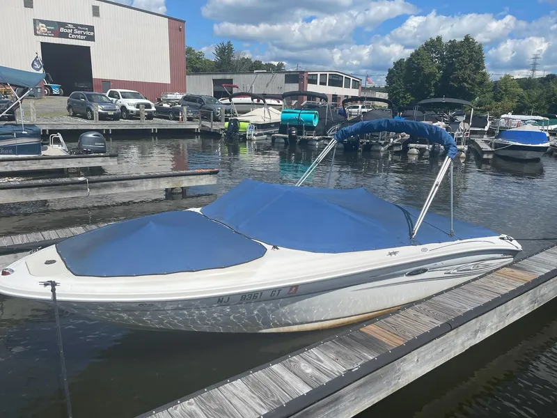 Slide: The Image of 2004 Sea Ray 185 Bow Rider docked at a marina under a blue sky. - 1