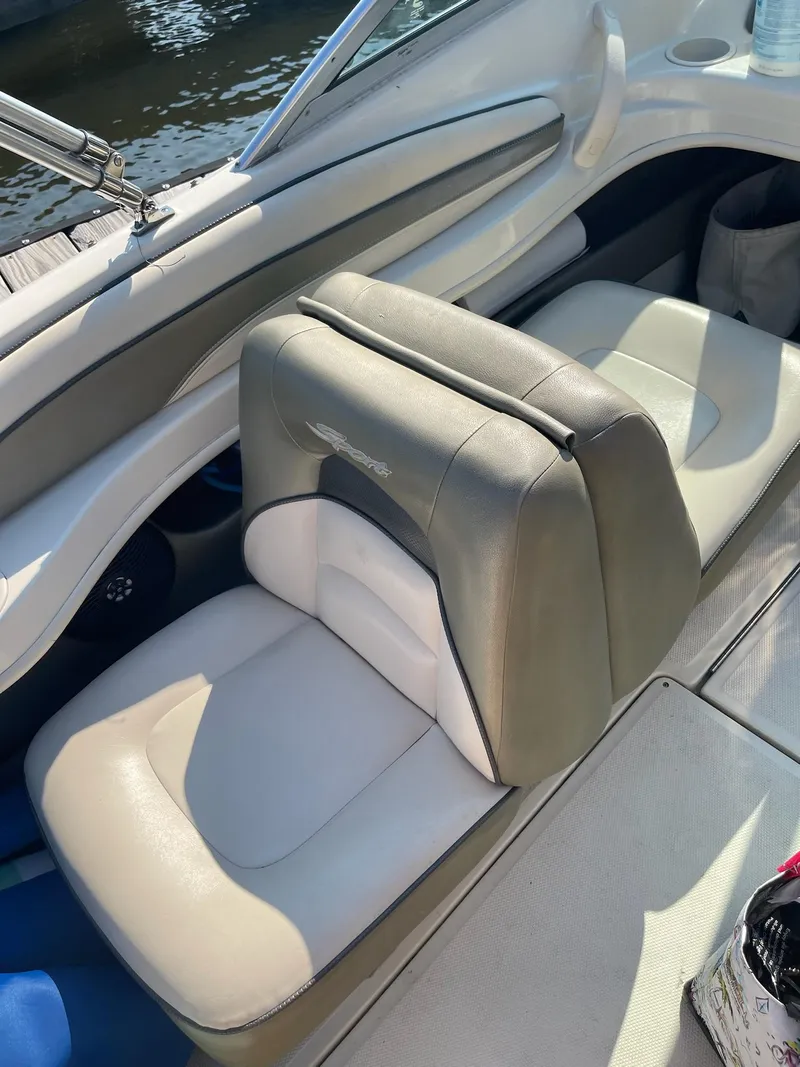 Slide: The Image of 2004 Sea Ray 185 Bow Rider interior seating, featuring beige and white upholstery. - 11