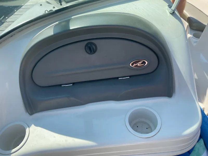 Slide: The Image of 2004 Sea Ray 185 Bow Rider dashboard with storage compartment and cup holders. - 12