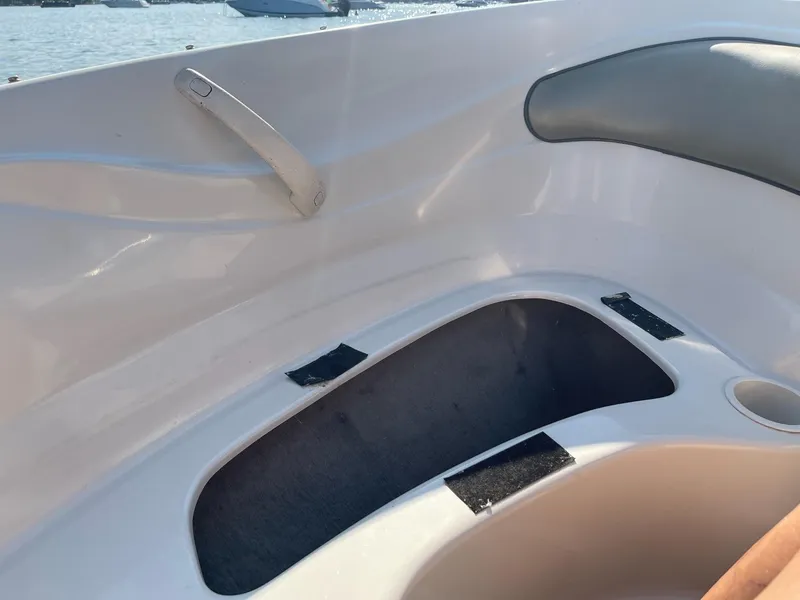 Slide: The Image of 2004 Sea Ray 185 Bow Rider interior storage compartment with cup holder, featuring sleek design. - 16