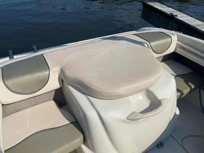 Slide: The Image of 2004 Sea Ray 185 Bow Rider interior with cushioned seating by the water. - 19