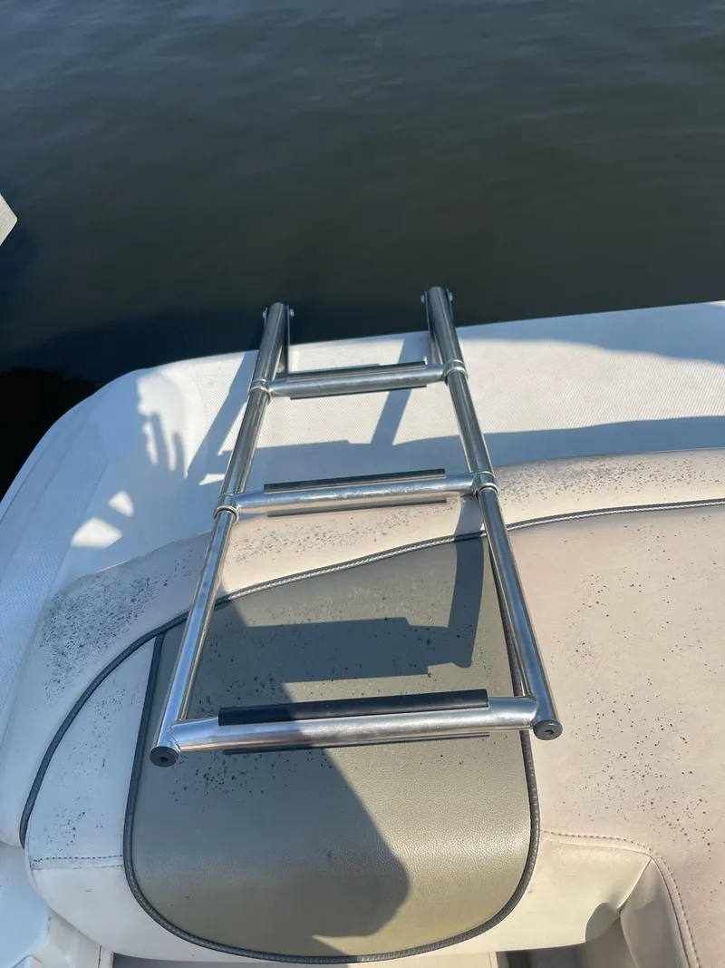 Slide: The Image of 2004 Sea Ray 185 Bow Rider swim ladder on boat deck by water. - 21