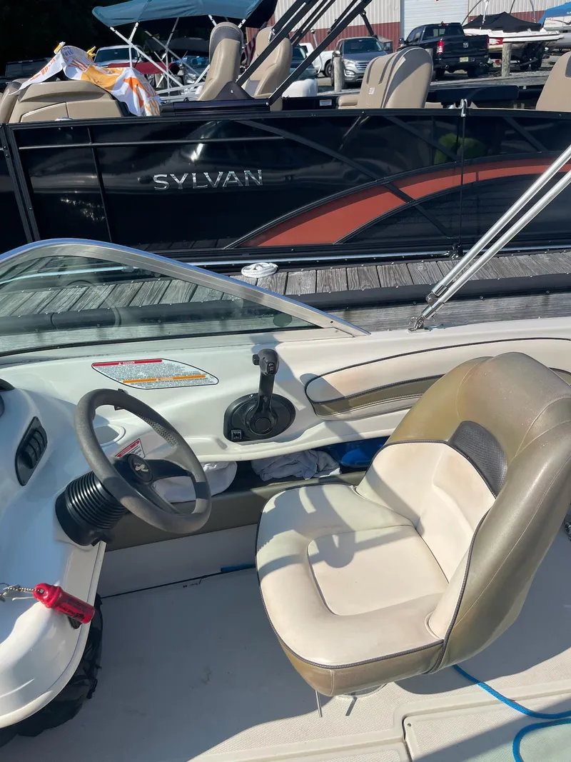 Slide: The Image of 2004 Sea Ray 185 Bow Rider interior with steering wheel and seating. - 9