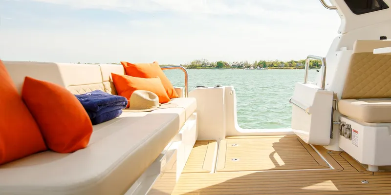 Slide: The Image of Aquila 36 Sport 2021 boat interior with orange cushions and scenic water view. - 18