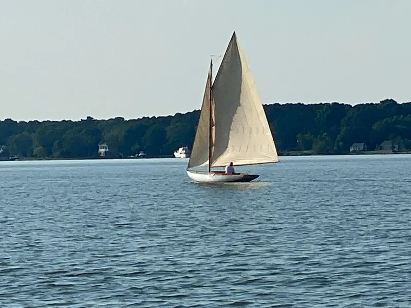 Slide: The Image of Sailing on calm waters, a 1916 Herreshoff Buzzards Bay 15 glides gracefully. - 2