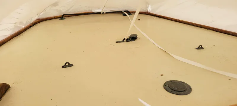 Slide: The Image of 1916 Herreshoff Buzzards Bay 15 boat deck with fittings and white cover. - 7