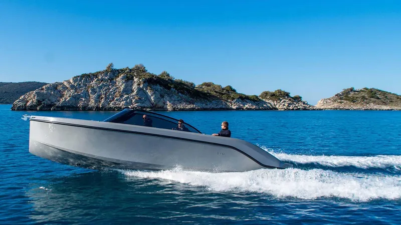 Slide: The Image of Modern Rand Supreme 27 boat cruising on clear blue water near rocky islands, 2025 model. - 10